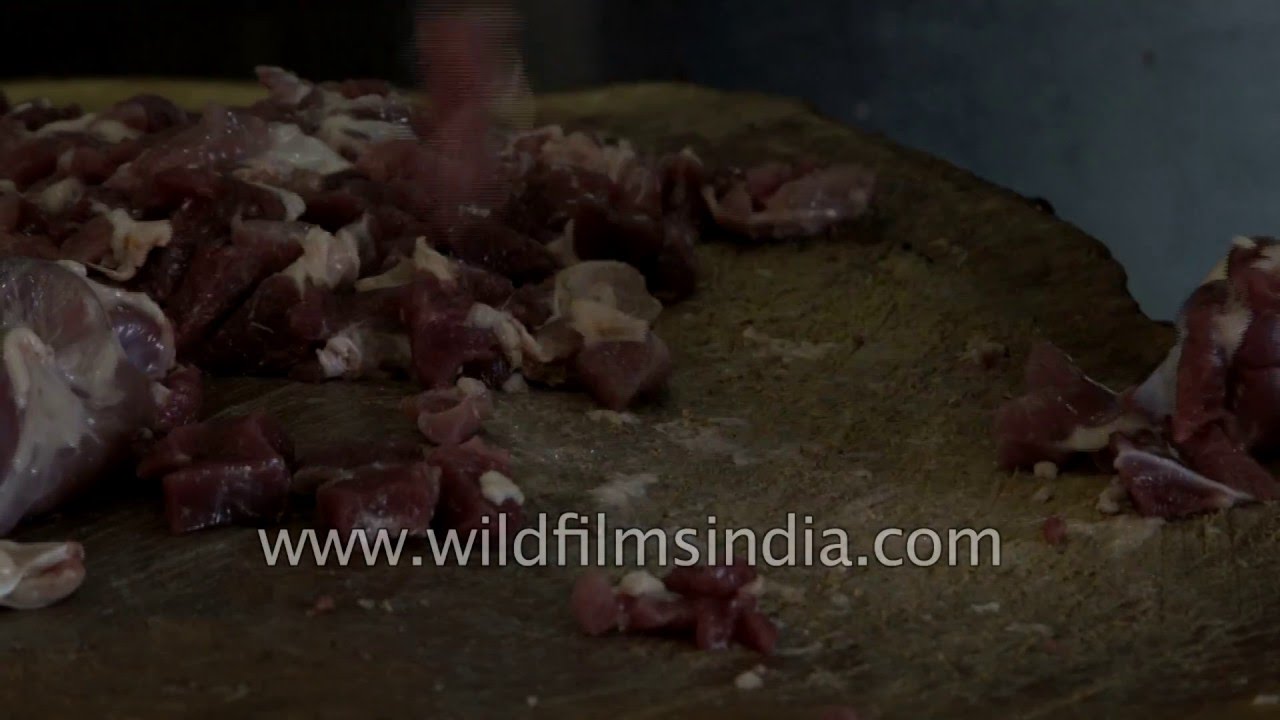 Butcher chops mutton at a shop in Madurai
