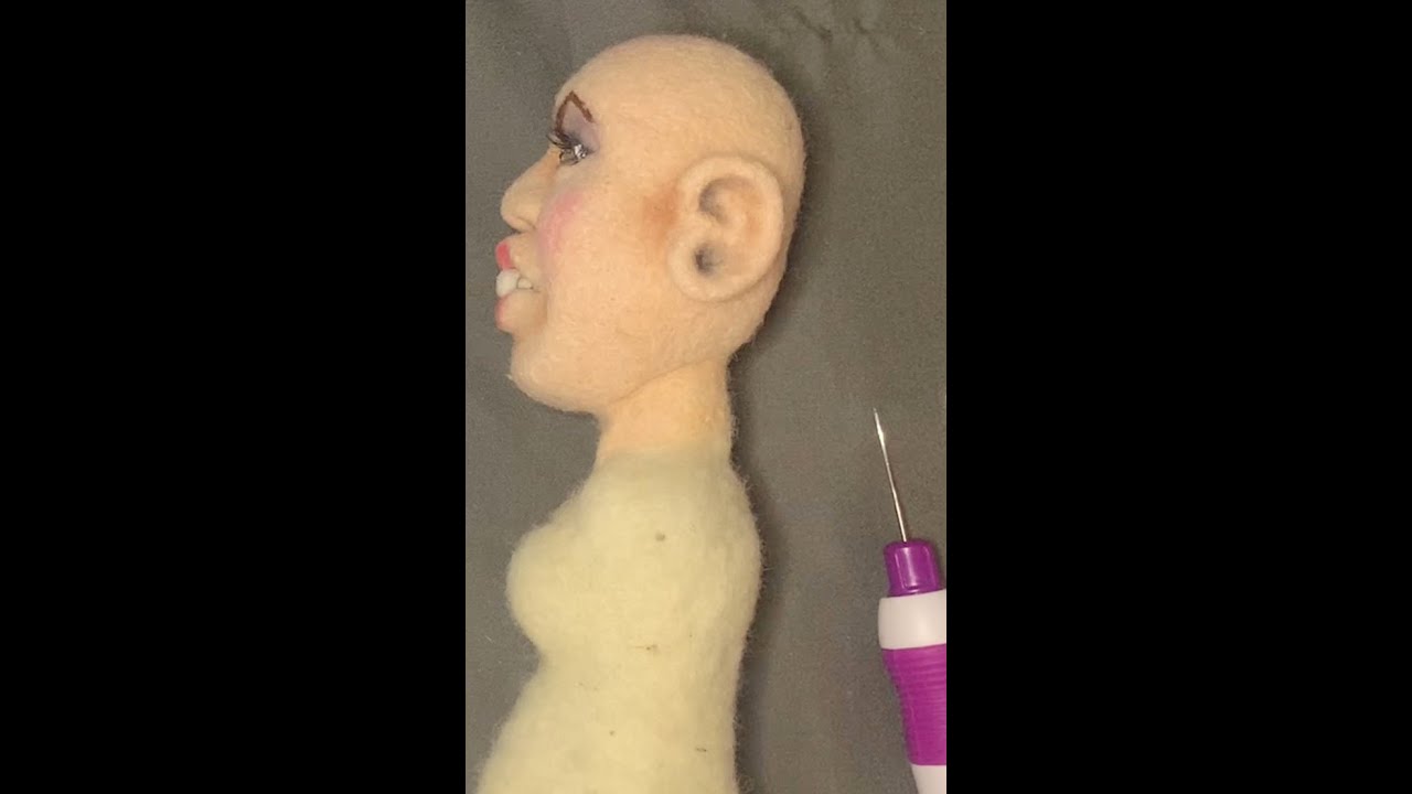 Needle felting the body of a doll.