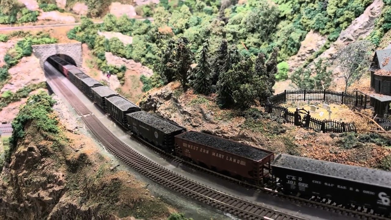 PRR Q2 and medium coal train descend a grade through tunnels at John K's HO layout.