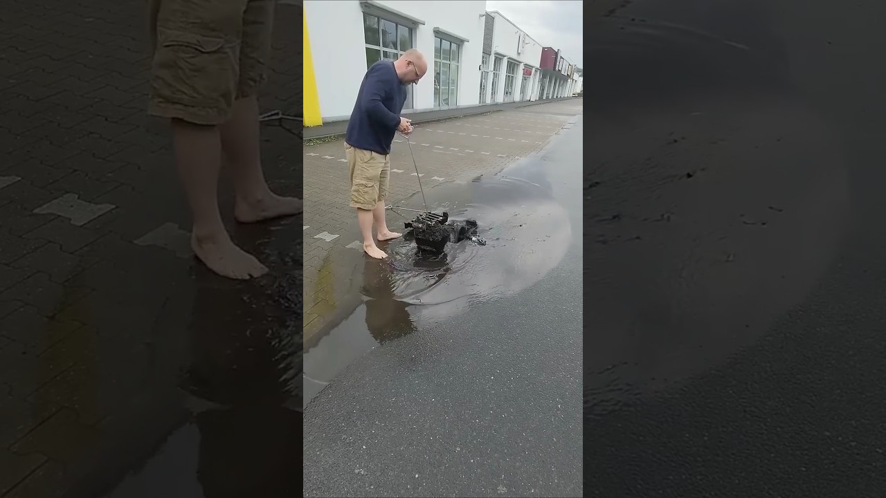 S#067-1 Unclogging a storm drain on a parking space after rain in Germany, #shorts