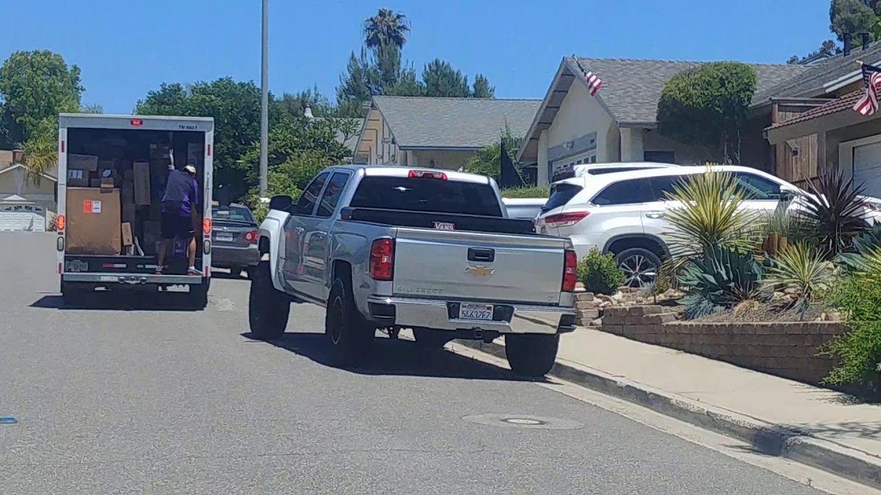 FedEx delivery riding at the back of U-haul while delivering in Mission Viejo