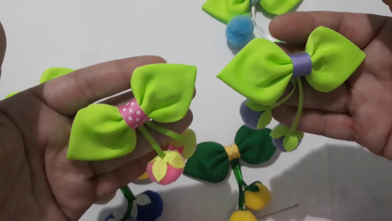 Frutinhas de pompom no laço folhinha, com acabamento no bico de pato