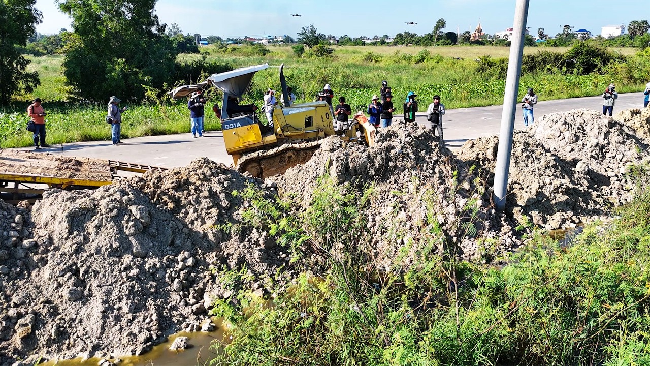 Great bulldozer operator pushes soil filling land with 5 tons dump trucks perfectly