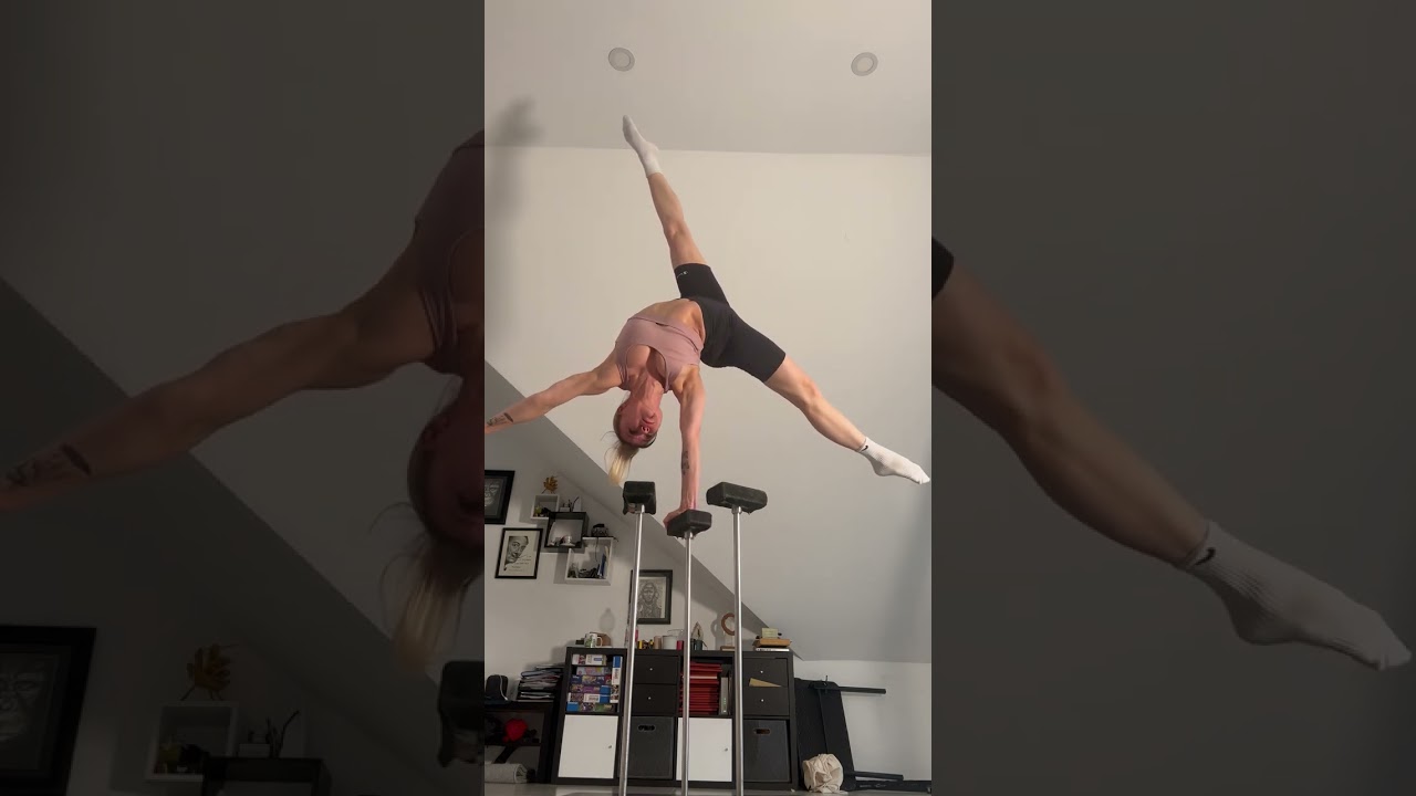 Person does a one arm handstand on canes!
