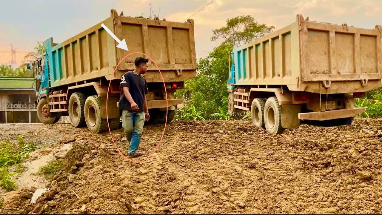 The dump truck is loading 20 trucks of soil for the tractor to push