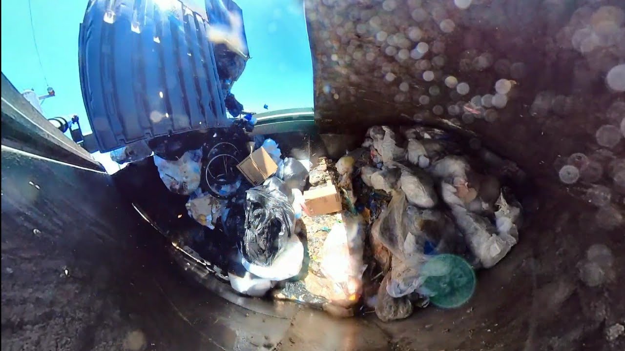 Waste Management garbage truck inside hopper view.