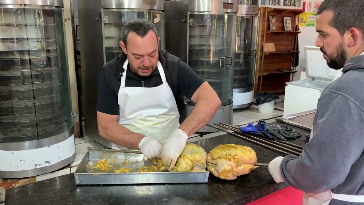 Espetando e colando o frango para assar no assador de espeto