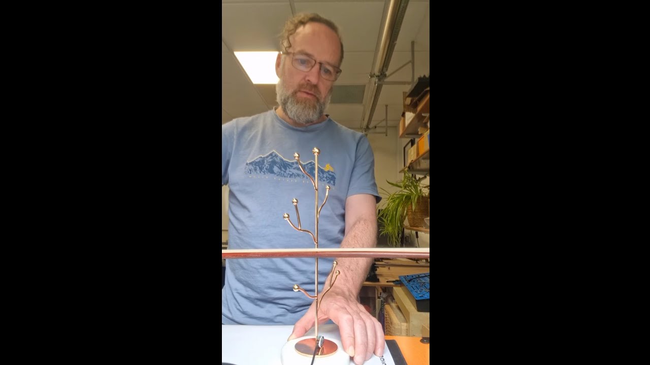 Bowed metal ornament with coupled resonances