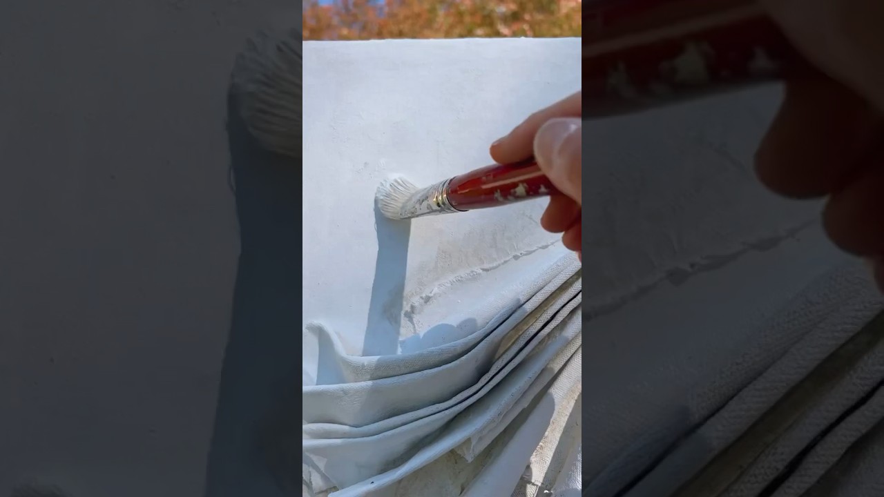 Applying a silky layer of oil paint to a wall sculpture. 