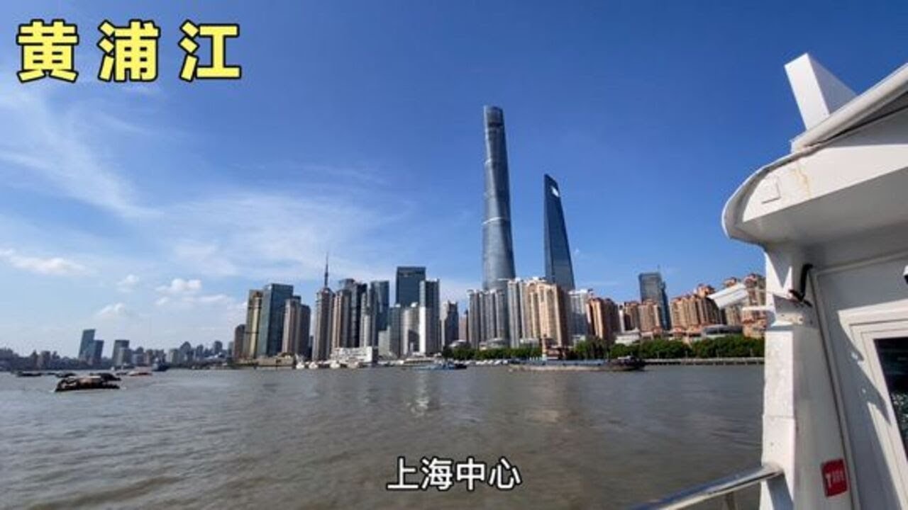 在上海坐船游览黄浦江，邮轮来回穿梭，周围都是高楼环抱