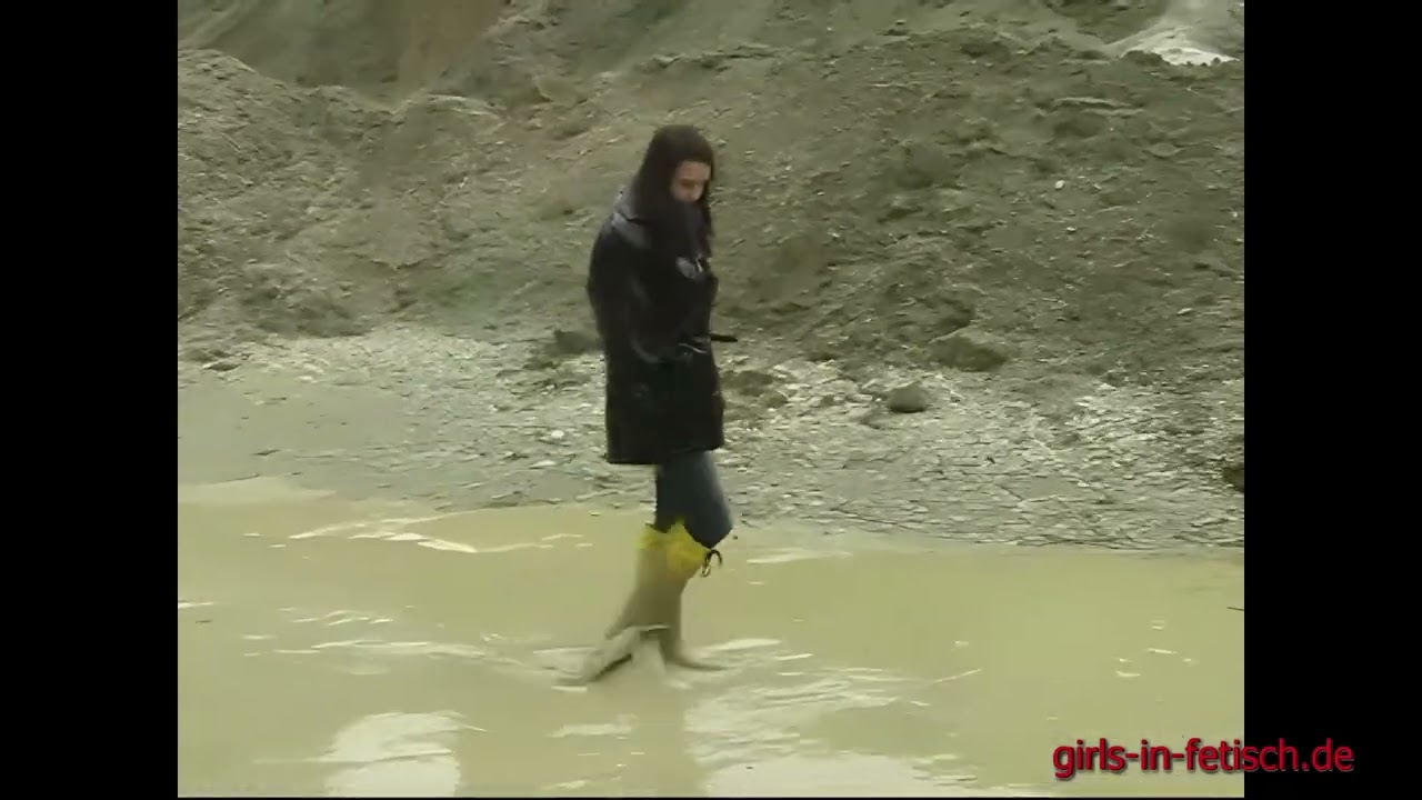 Gelbe, hohe Gummistiefel im Matsch (Singlemovie102)