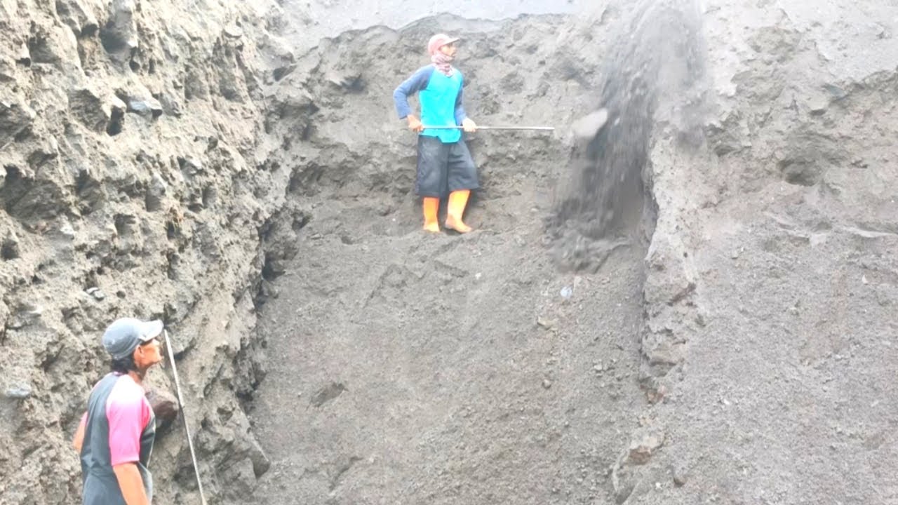 As miners scrape away black sand on the cliffs, other miners remove rocks beneath them.