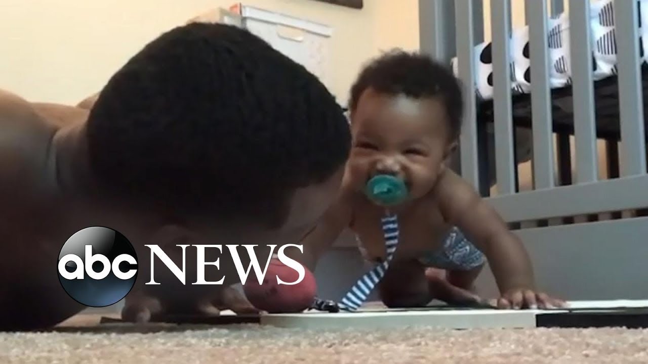 Adorable baby does push-ups with his dad
