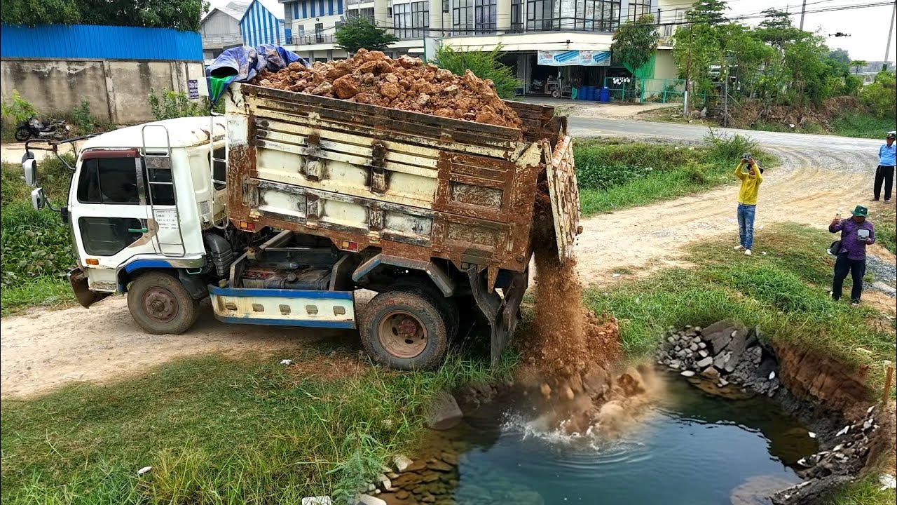 First Start New project landfilling by using dump truck 5T unloading soil and old bulldozer pushing 