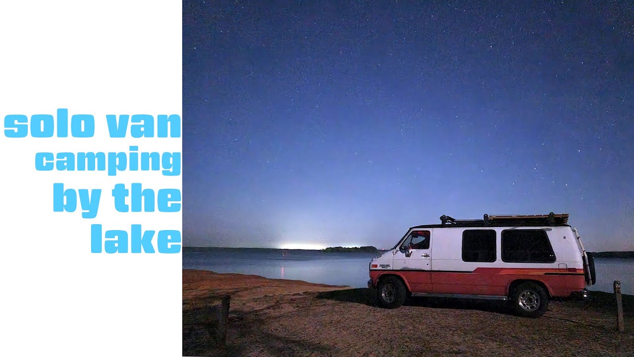 Solo van camping at the lake with the dog