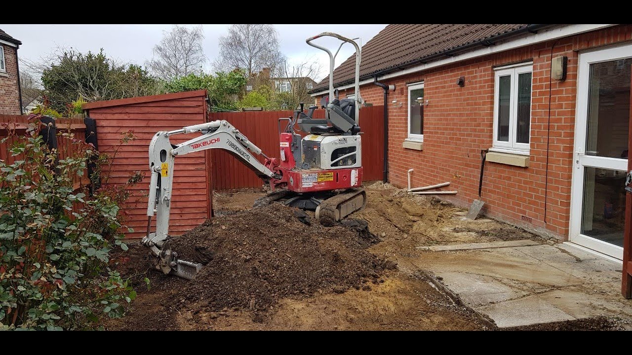 Digging out a garden with a micro digger and dumper Takeuchi TB210R and Tracked Dumper