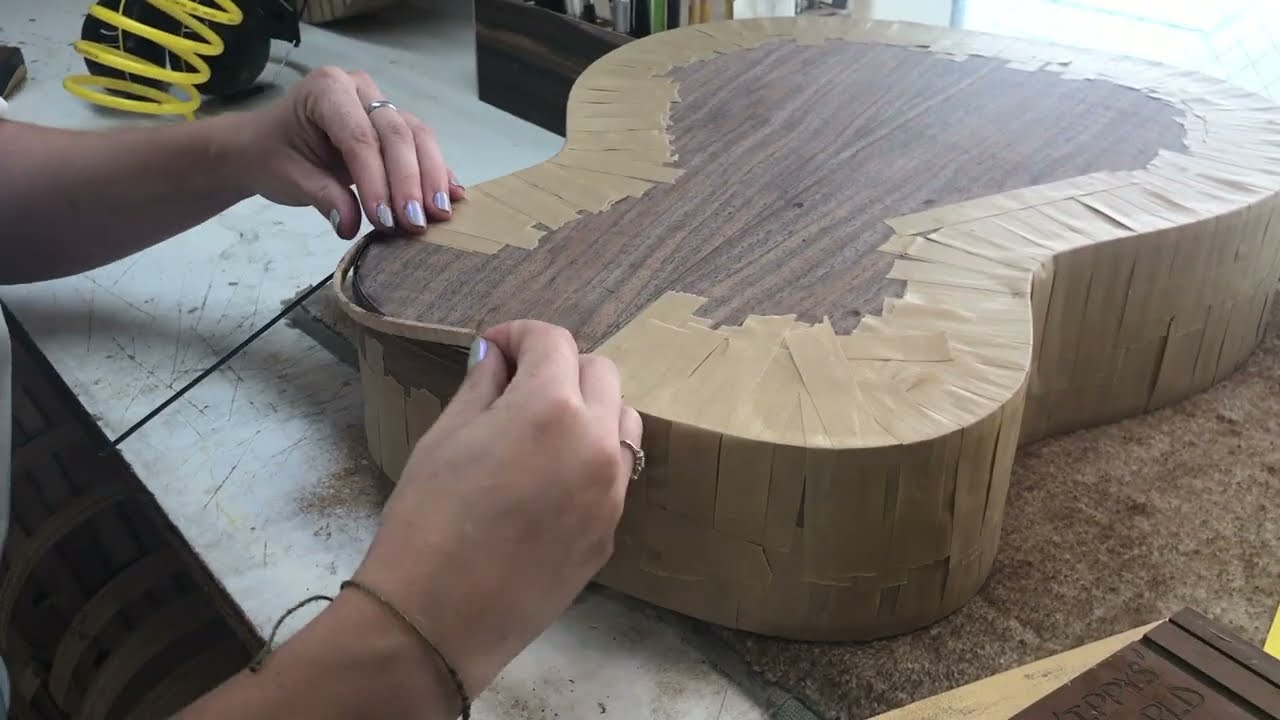 Olivia Elia - a builder at Thompson Guitars talks about Maple Binding process on a 0000-Walnut/Lutz