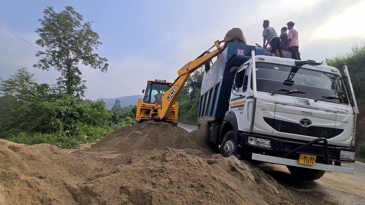 jcb 3dx super loading sand into a dump truck