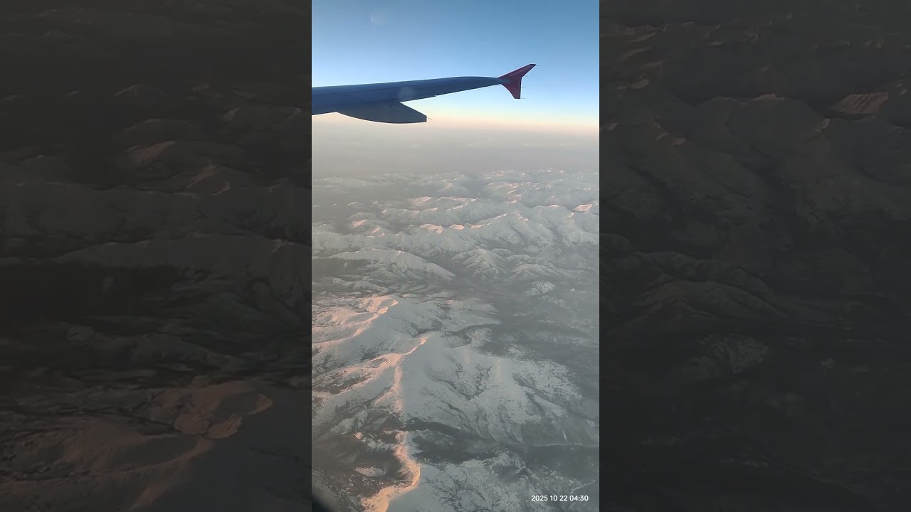 Рассвет в горах из окна самолёта. Розовые лучи где-то за Байкалом...