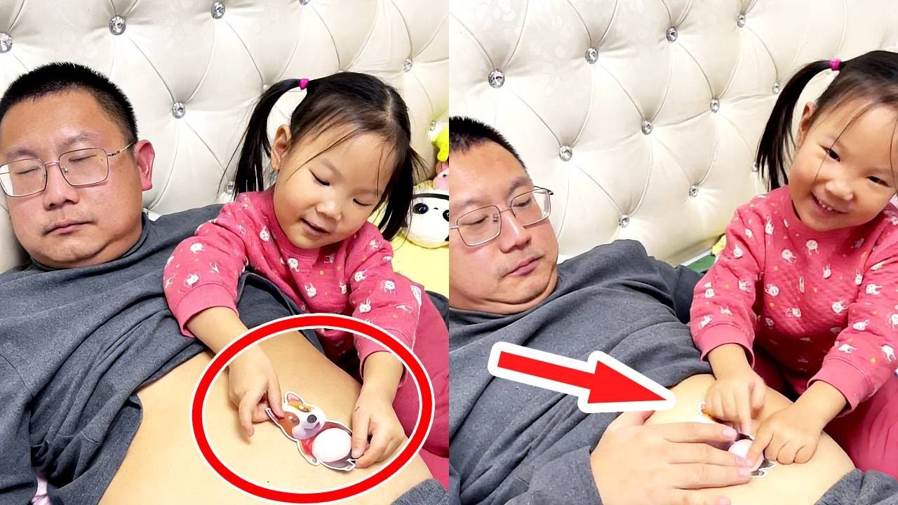 The girl is sticking teddy bear stickers on her dad's belly! So cute.
