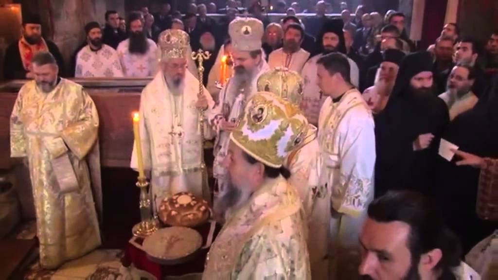 Serbian Patriarch Irineus chants with monks and People in ancient Orthodox Monastery.