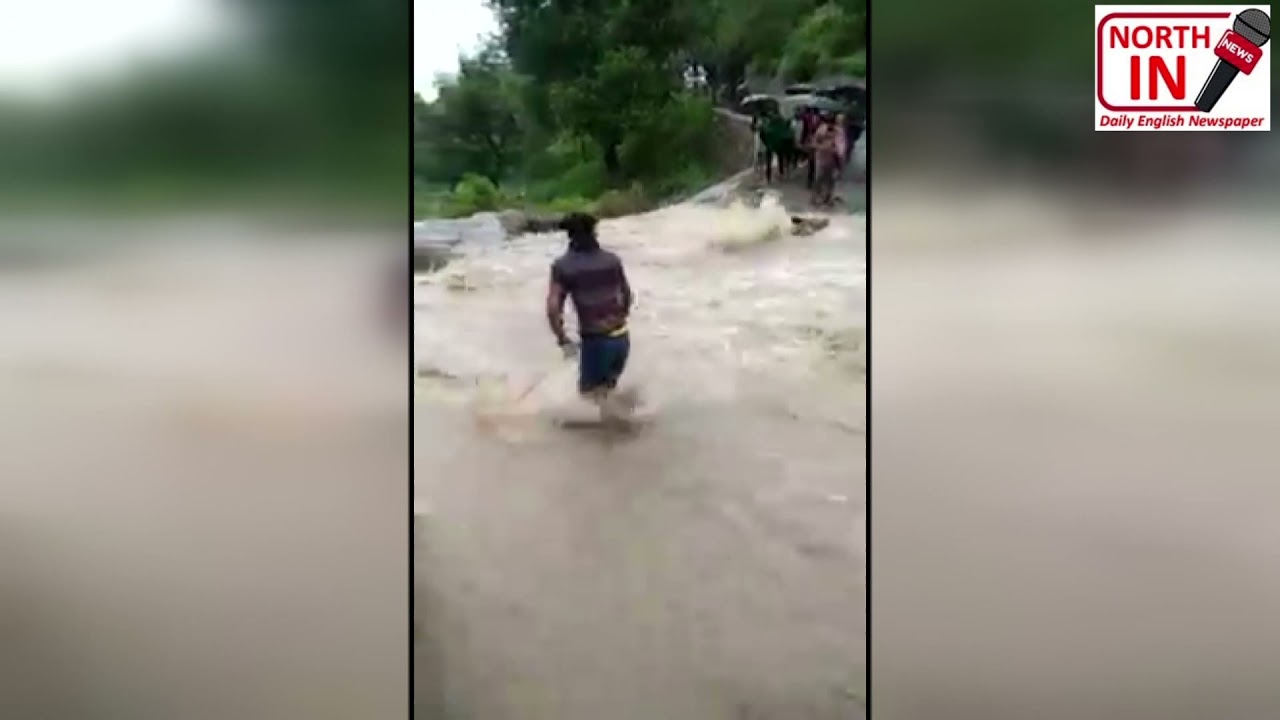 Serni Nallah by using rope to cross flooded Mahore-Bathoie road