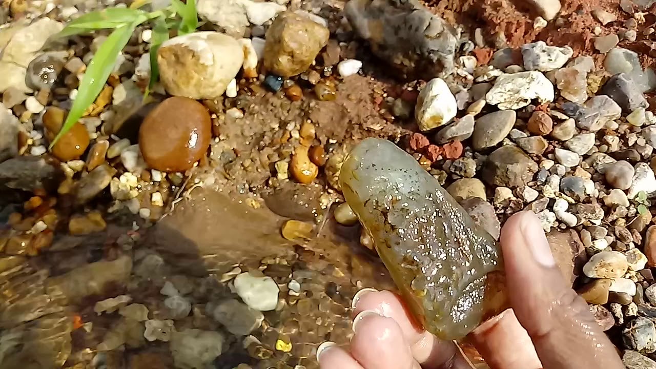 Garimpando na beira do rio com muitas pedras