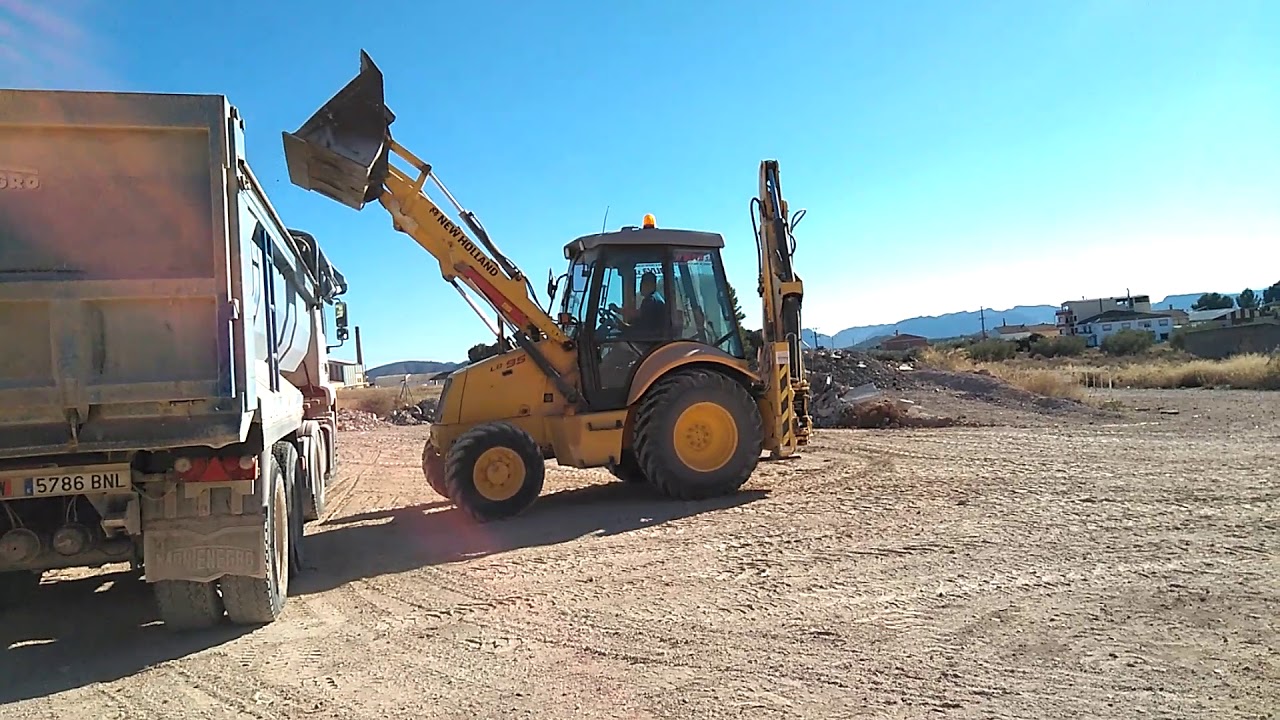 Mixta New Holland lb95b cargando Man TGA.