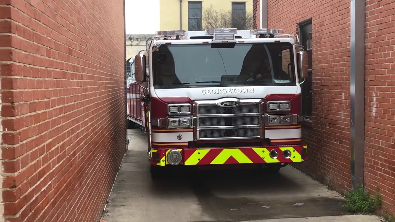 Tiller Truck Making Turn Down Narrow Alleyway - Tractor Drawn Aerial