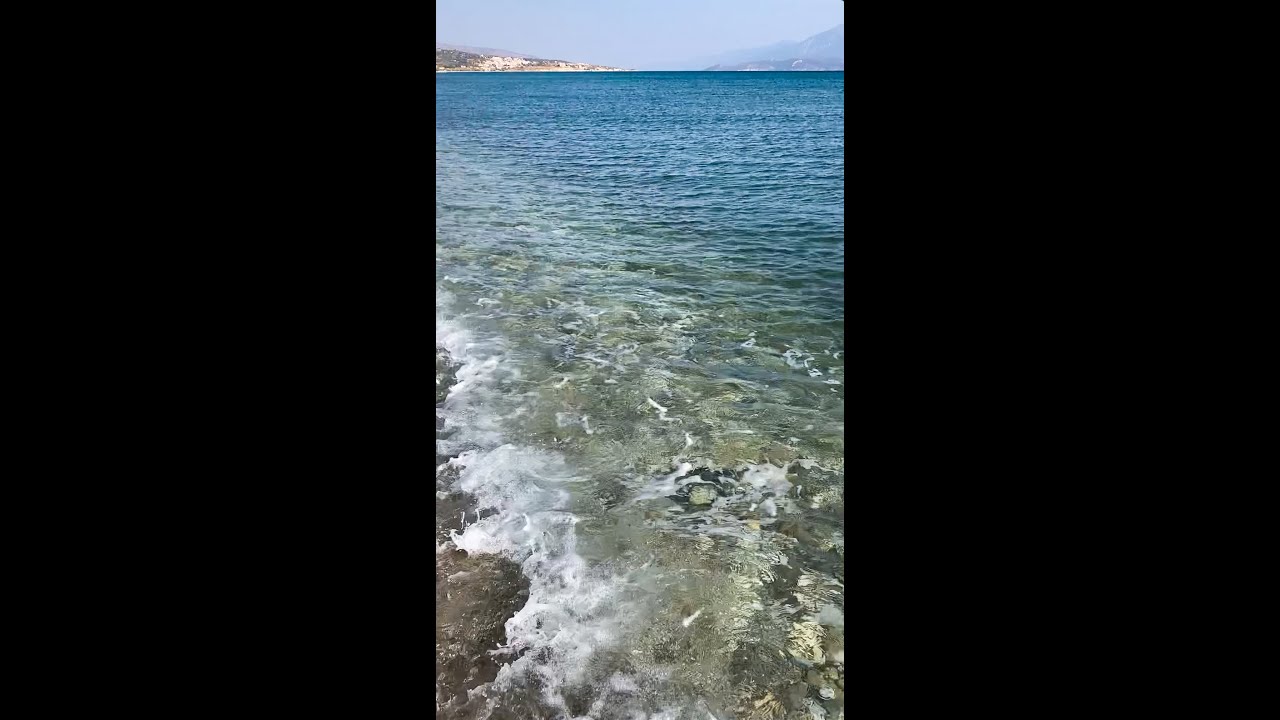 Samos/Greece  - Refreshing steps through small waves along the waterline on Potokaki beach