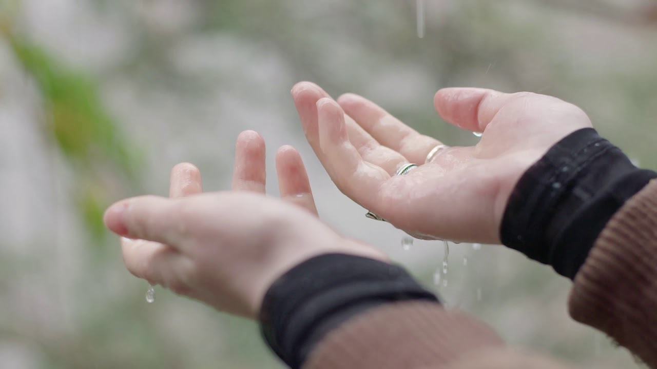Rain falling on hands in slow motion - no Copyright