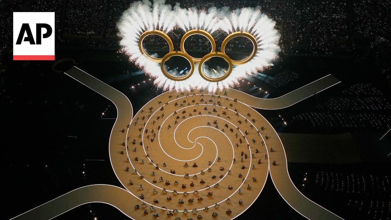 AP journalists join thousands at the San Siro Stadium to watch the Winter Olympics opening ceremony