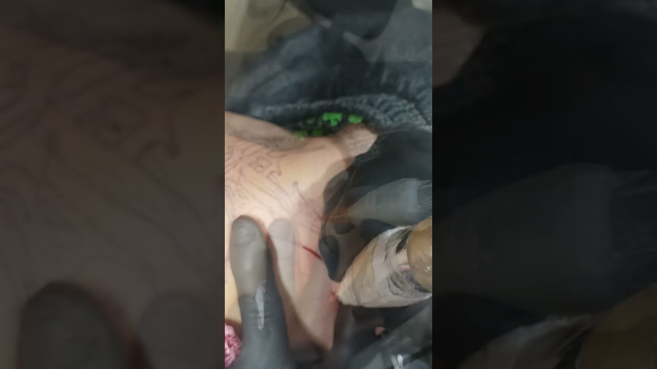 Tattoo de um rascunho de arma na cintura . 