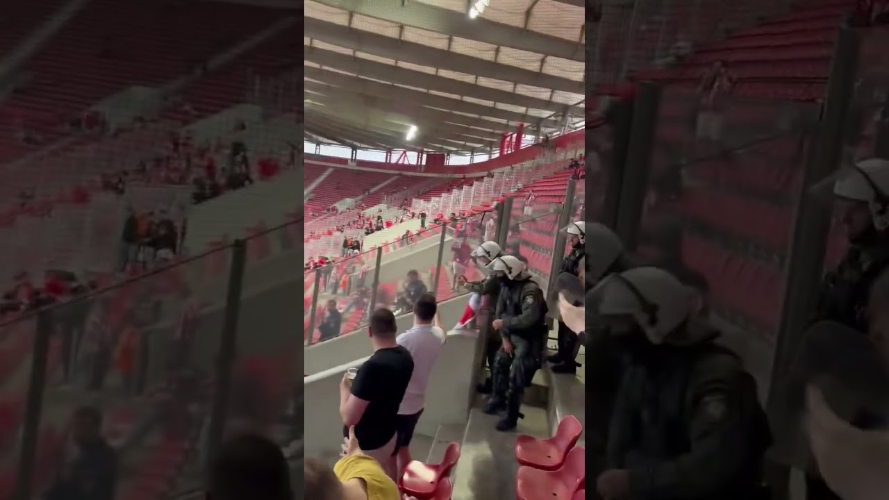Aston Villa fan with a Panathinaikos scarf whilst this Olympiacos fan  holds Birmingham badge