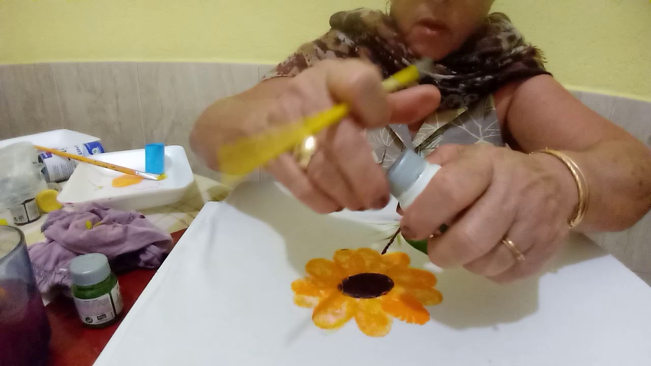 Pintando um girassol com uma tampinha.