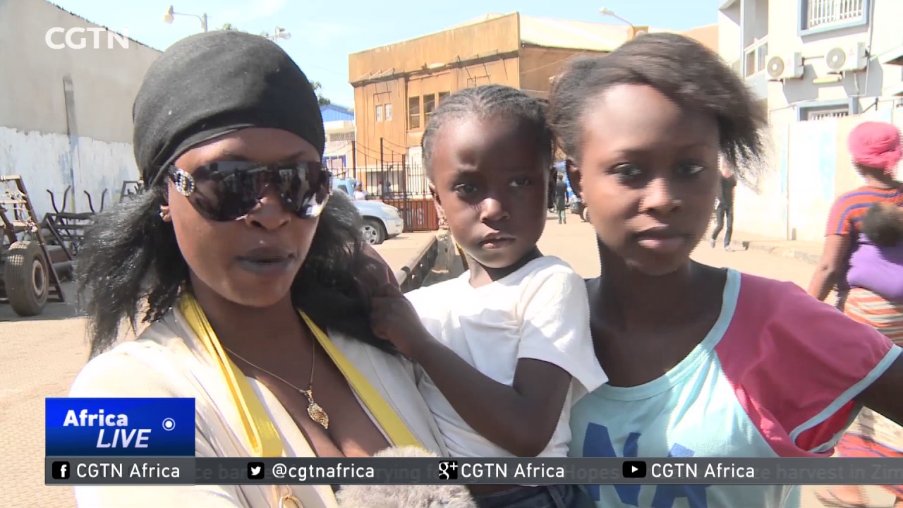 Gambians await the arrival of President Adama Barrow