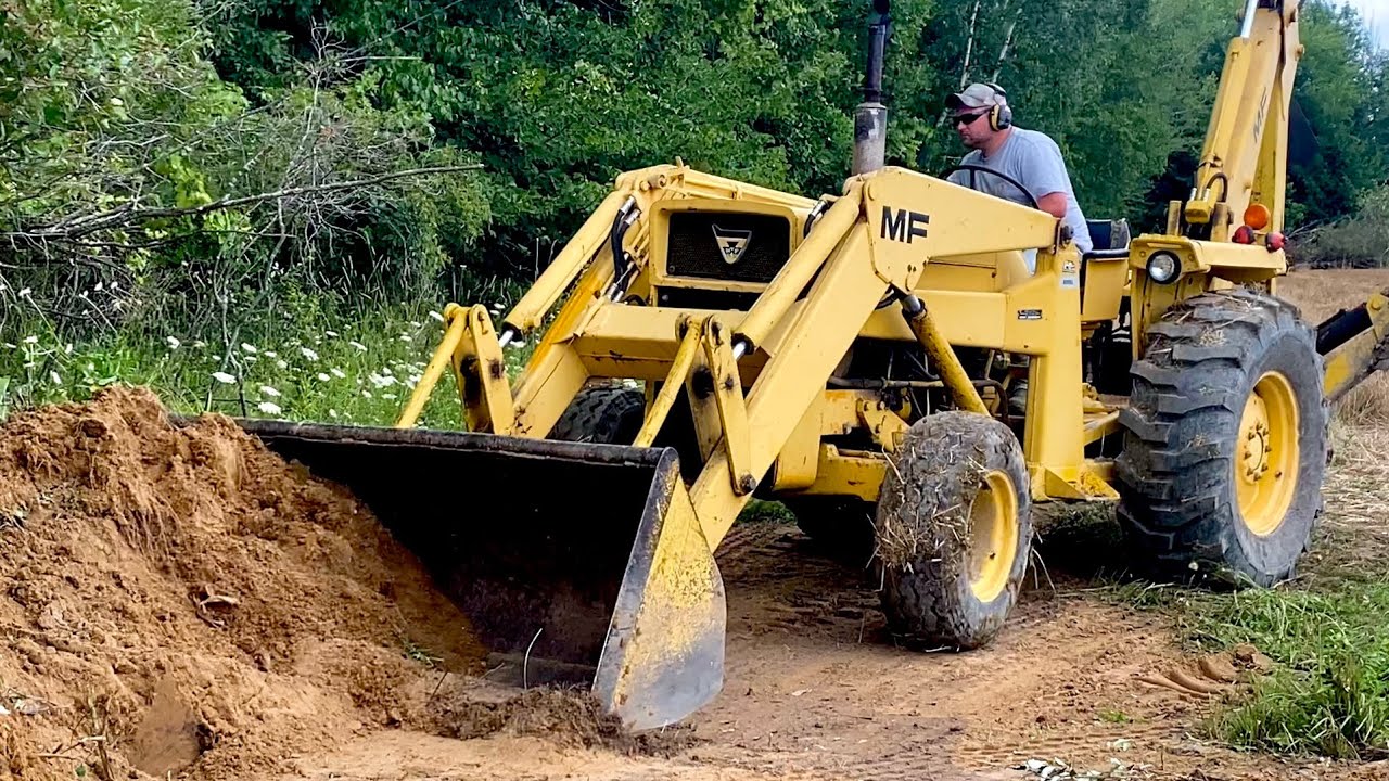 Massey Ferguson model 50A backhoe moving sand. Sound only.