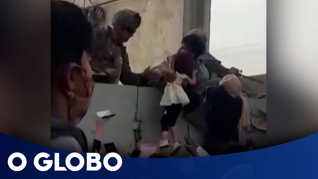 Mães e pais entregam filhos a militares no aeroporto de Cabul