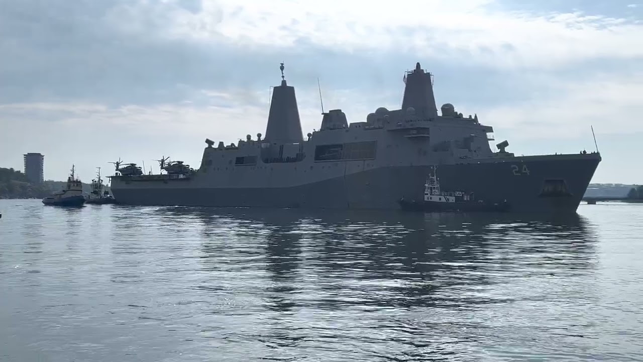 USS Arlington (LPD-24) USA in Stockholm Sweden 2022-08-05 approaching the harbor with help of tugs.