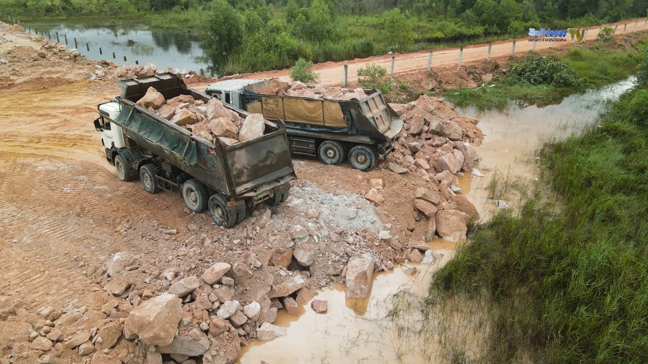 Nicely Powerful Stones Filling Up The Land Into Flood Area By KOMATSU Bulldozers With Dump Trucks
