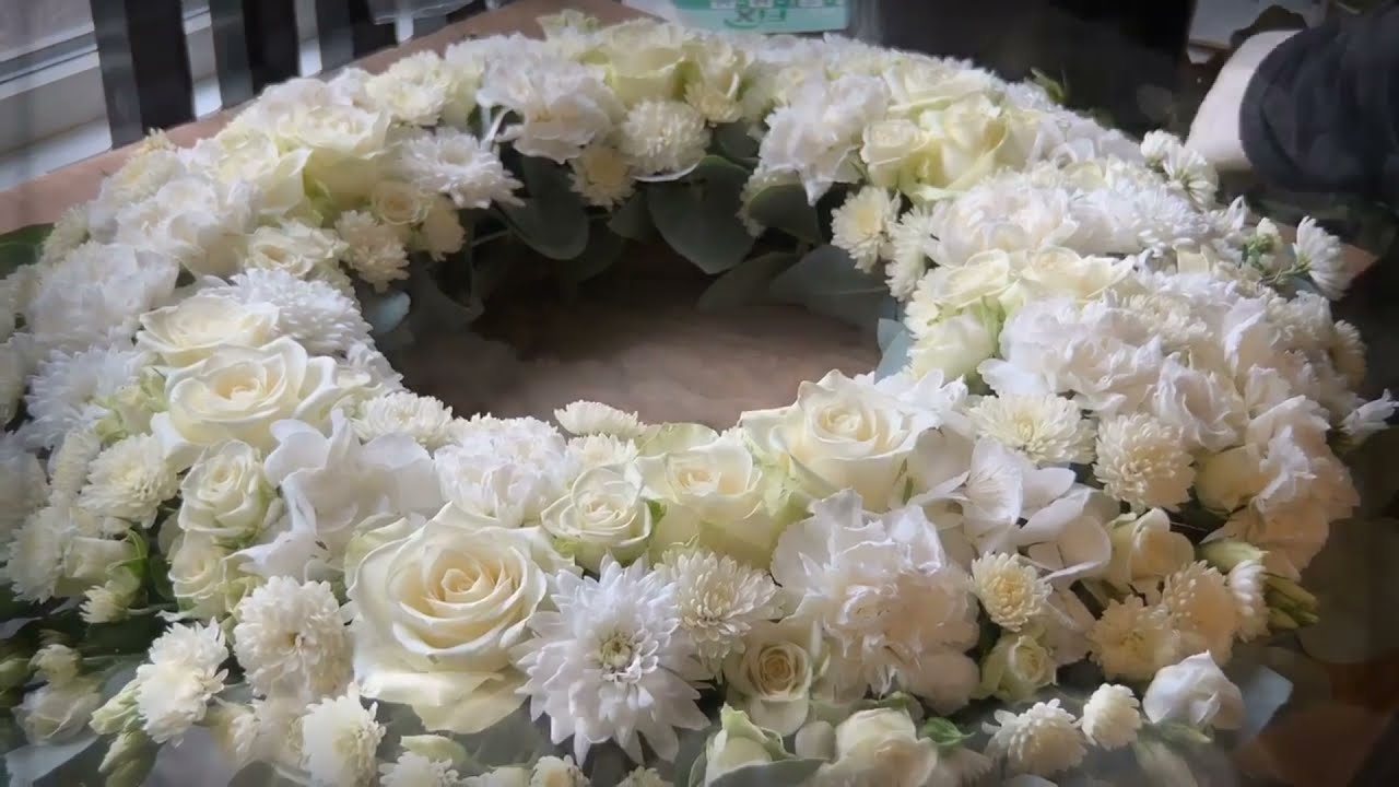 Blomsterdekoratør binder Krans til begravelse