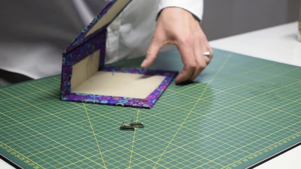 Wie kommt die Metallecke an die Schachtel?