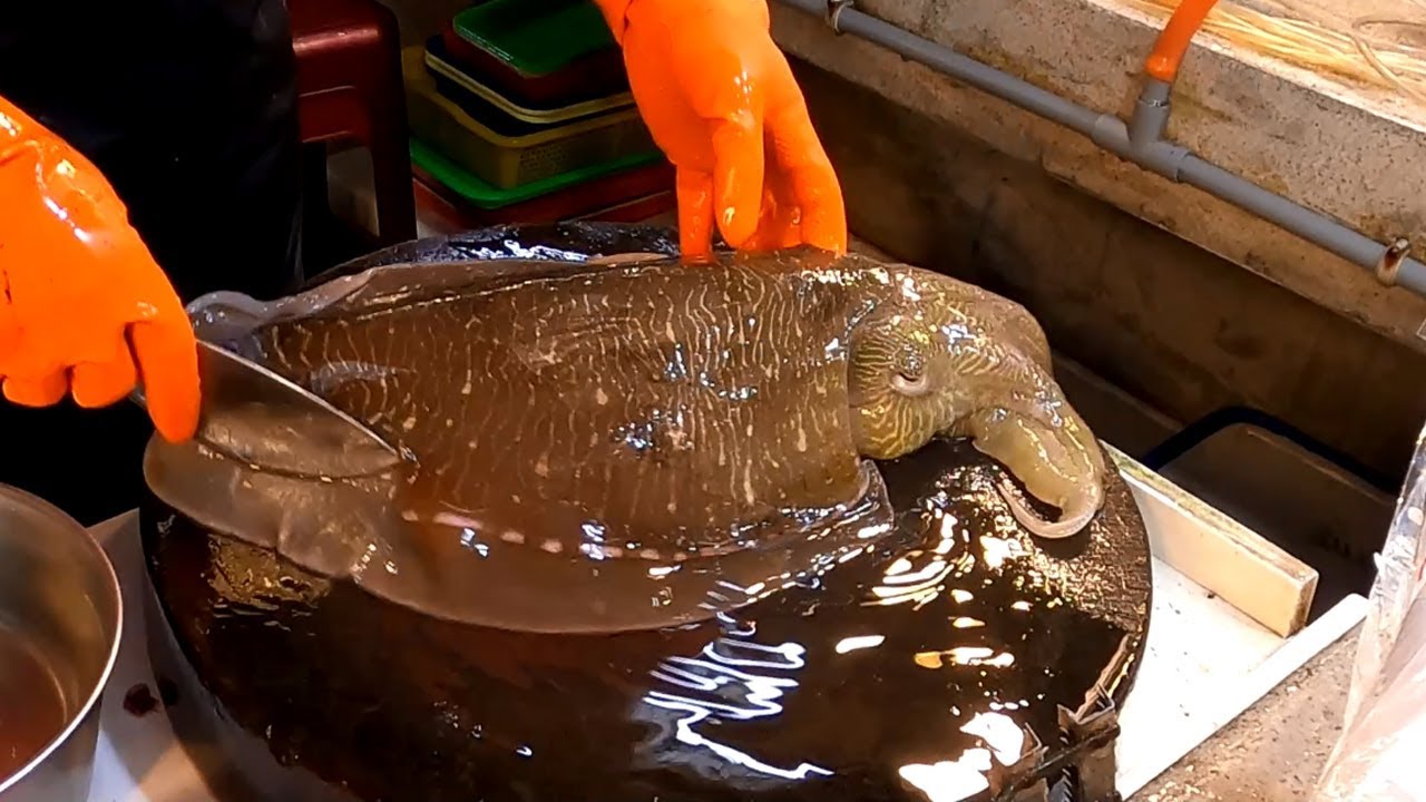Резка живой каракатицы на рынке морепродуктов - тайваньская уличная еда