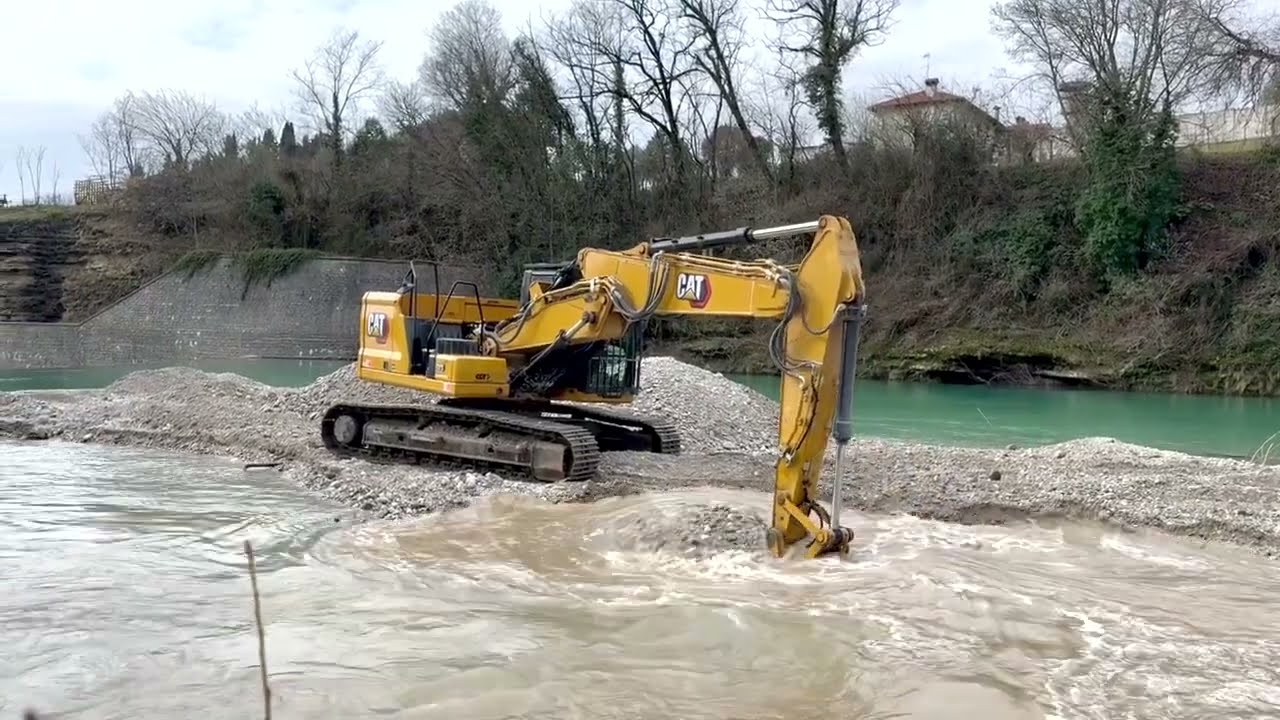 CATERPILLAR 323 NG digging gravel in Natisone River, Cividale del Friuli