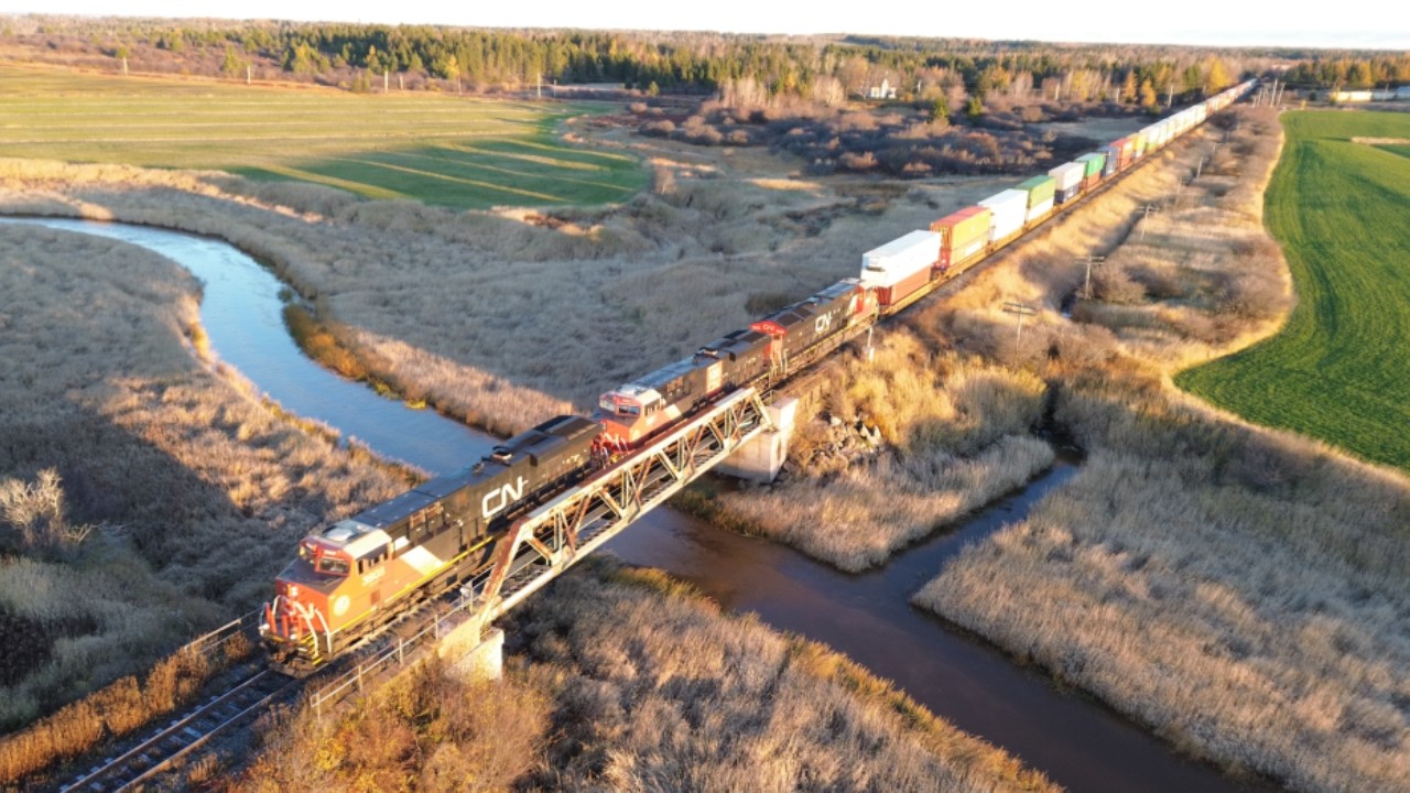 Awesome Aerial 4K View during Golden Hour! Big Stack Train CN 120  passing Nappan, NS at Track Speed