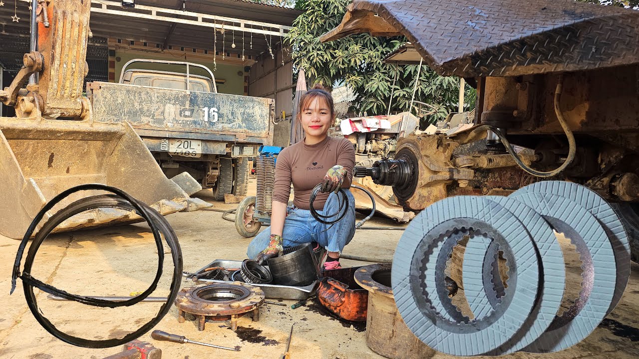 Mechanic girl maintains and replaces the brake system for the excavator