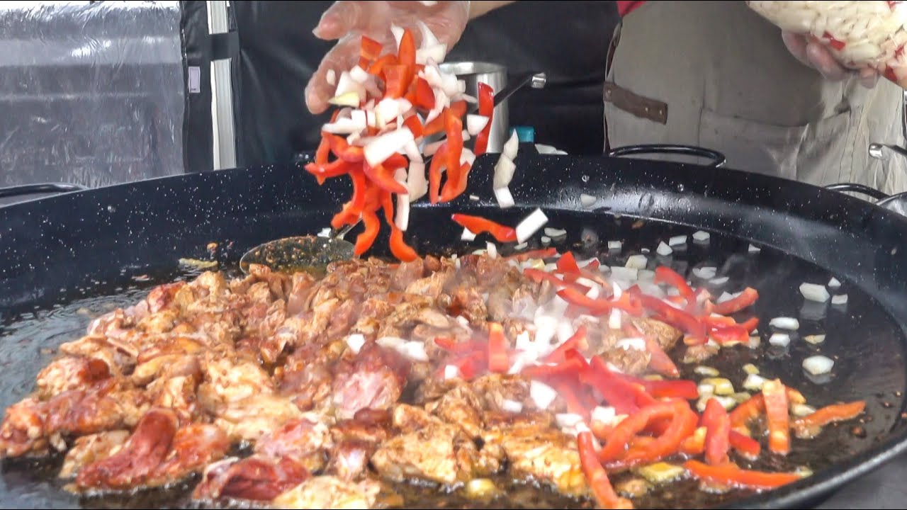 Cooking Spanish Paella with Chicken, Chorizo Sausage and Rice. London Street Food