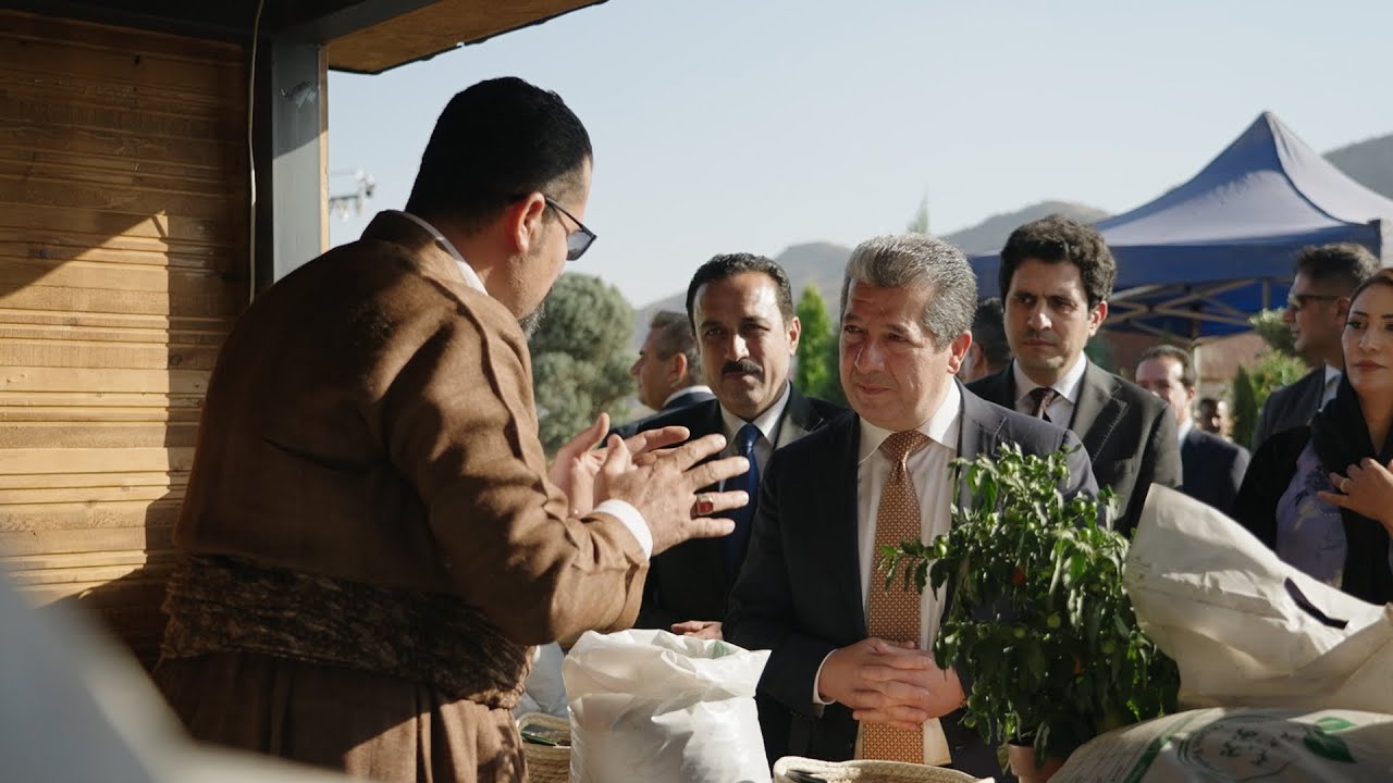 PM Masrour Barzani speaks to local farmers and tries local produce