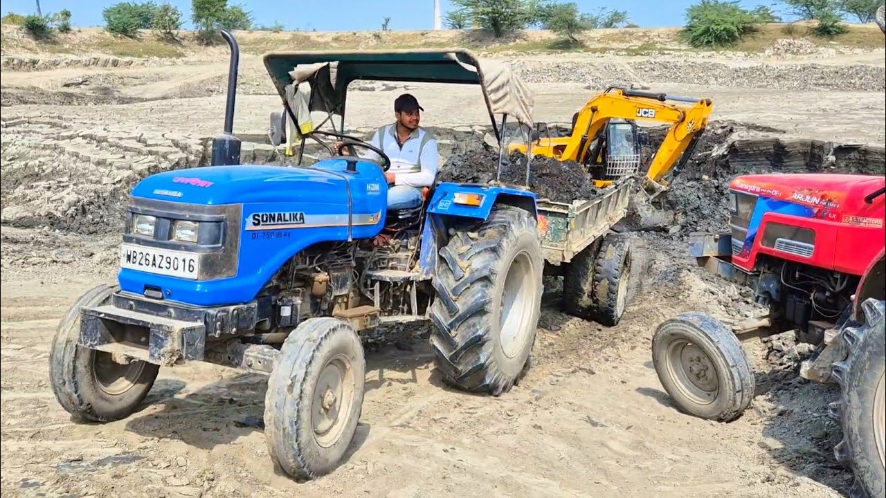 JCB 140 Machine loading mud in Mahindra Sonalika and Powertrac Tractor / Tractor Trolley loading 