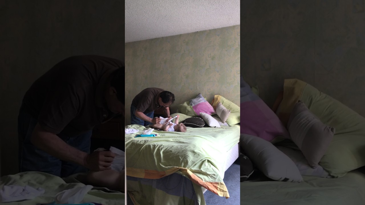 Abuelo cambia pañal de bebe/ Granddad changes baby's diaper.